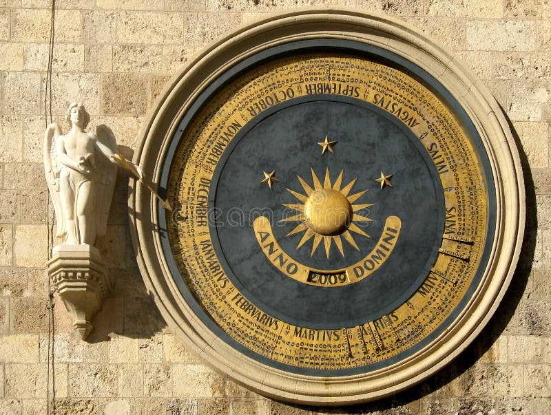 Round perpetual calendar with an angel showing the day of the year, on a wall of the bell tower in Messina, Sicily. Round perpetual calendar with an angel showing the day of the year, on a wall of the bell tower in Messina, Sicily