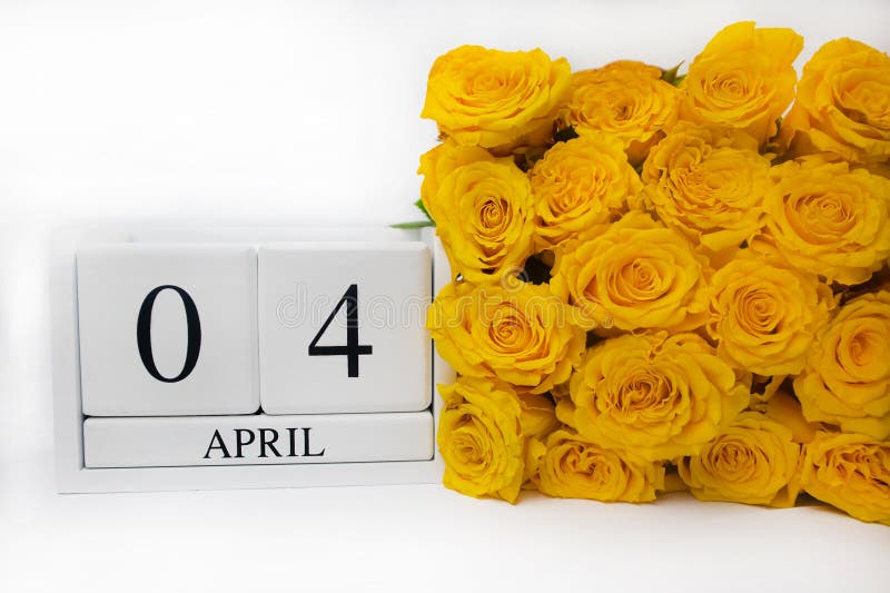 Wooden white calendar 4 april and yellow roses on a white background. The concept of a holiday, a plan, an important event,date, event, birthday, postcard, text,plan,wedding, vacation,day,copy space. Wooden white calendar 4 april and yellow roses on a white background. The concept of a holiday, a plan, an important event,date, event, birthday, postcard, text,plan,wedding, vacation,day,copy space