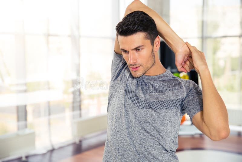 Calentamiento del hombre de la aptitud en el gimnasio imagen de archivo libre de regalías Calentamiento del hombre de la aptitud en el gimnasio imagen de archivo libre de regalías