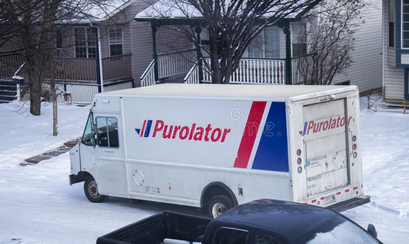 A Purolator delivery truck outside of a residential area during winter