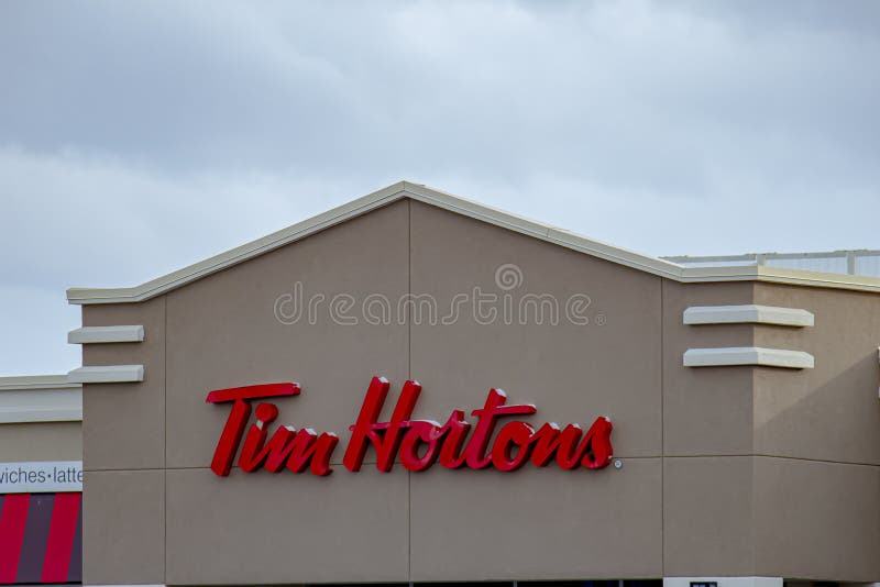 MONTREAL, CANADA - NOVEMBER 6, 2018: Tim Hortons Logo In Front Of One Of  Their Restaurants In Quebec With Their Slogan In French In The Background. Tim  Hortons Is A Cafe And