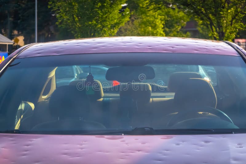 A car with hail damage and windshield that is cracked with the hood dented royalty free stock image
