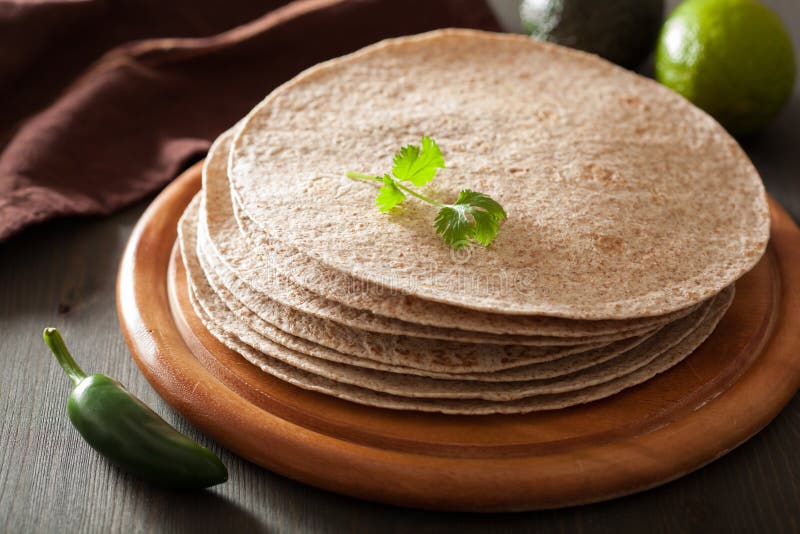 Cali pszeniczni tortillas na drewnianej desce i warzywach obraz stock Cali pszeniczni tortillas na drewnianej desce i warzywach obraz stock