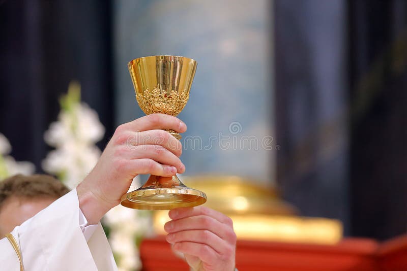 Calice nelle mani del sacerdote sull'altare durante la celebrazione della messa