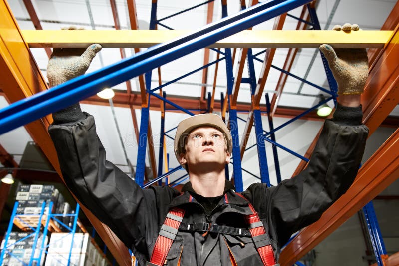 One warehouse worker in uniform with level examining quality of rack installation. One warehouse worker in uniform with level examining quality of rack installation