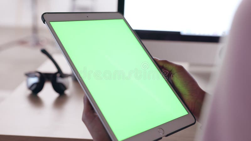 Call center worker défilant sur les médias sociaux sur une tablette numérique avec fond vert. technicien en train de regarder les banque de vidéos