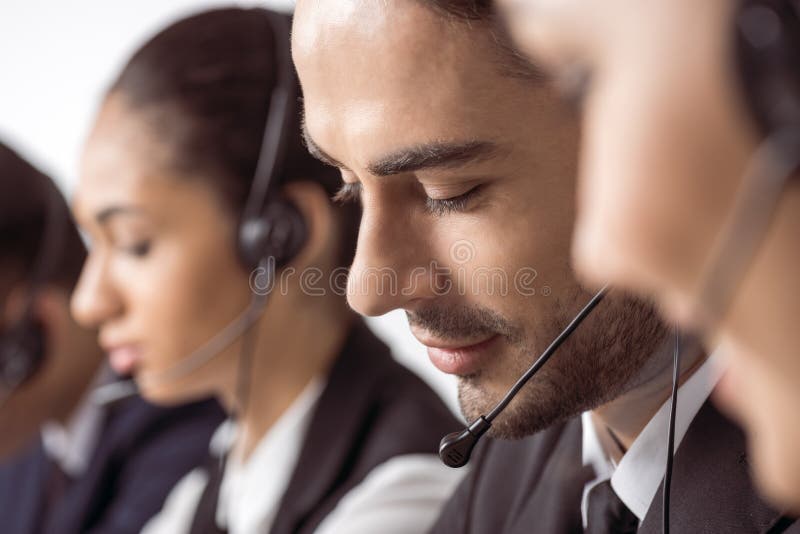 Call centreexploitanten in hoofdtelefoons die samenwerken royalty-vrije stock fotografie Call centreexploitanten in hoofdtelefoons die samenwerken royalty-vrije stock fotografie