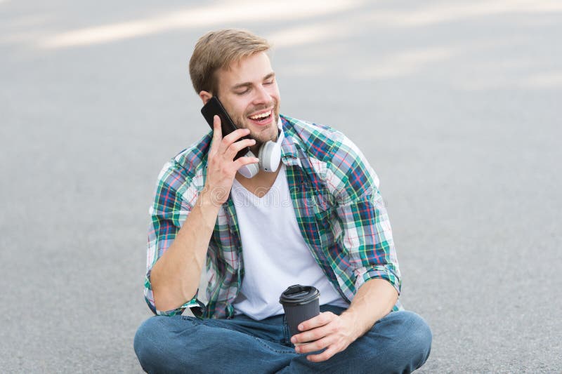 Call friend. Guy carefree student enjoy coffee outdoors. Life balance. Wellbeing and health. Having coffee break. Man stock photo Call friend. Guy carefree student enjoy coffee outdoors. Life balance. Wellbeing and health. Having coffee break. Man stock photo