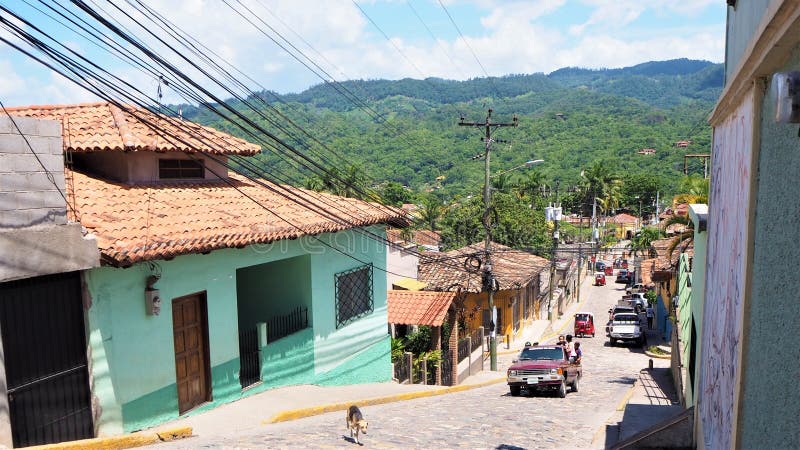 Calle de cobre de Honduras con autos y tuk tuk y un perro. Calle Copan en honduras centroamérica