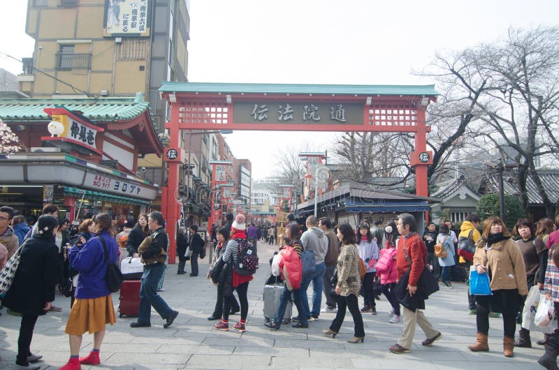 TOKYO, JAPAN - FEBRUARY 23,2015: Nakamise shopping street in Asakusa, Tokyo. The busy arcade connects Senso-ji Temple to it's outer gate Kaminarimon, which can just be seen in the distance. TOKYO, JAPAN - FEBRUARY 23,2015: Nakamise shopping street in Asakusa, Tokyo. The busy arcade connects Senso-ji Temple to it's outer gate Kaminarimon, which can just be seen in the distance