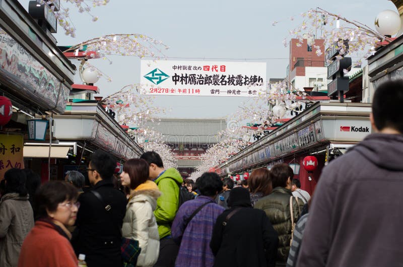 TOKYO, JAPAN - FEBRUARY 23,2015: Nakamise shopping street in Asakusa, Tokyo. The busy arcade connects Senso-ji Temple to it's outer gate Kaminarimon, which can just be seen in the distance. TOKYO, JAPAN - FEBRUARY 23,2015: Nakamise shopping street in Asakusa, Tokyo. The busy arcade connects Senso-ji Temple to it's outer gate Kaminarimon, which can just be seen in the distance