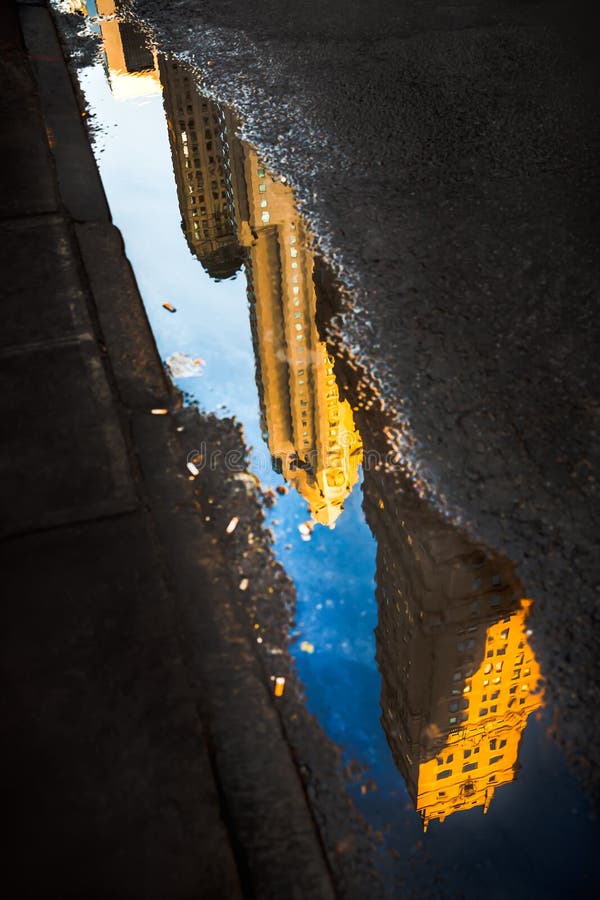 Calles de Manhattan Reflexión de los rascacielos en charcos fotografía de archivo Calles de Manhattan Reflexión de los rascacielos en charcos fotografía de archivo