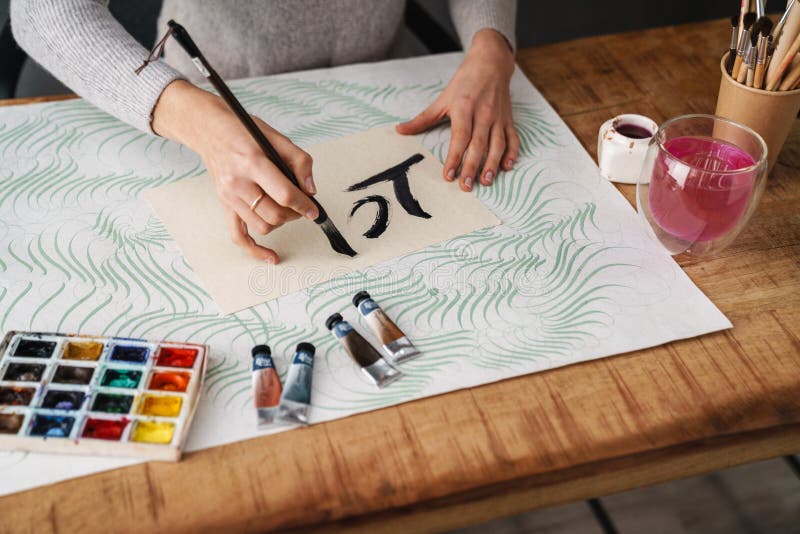 Calligrapher-skrivning när arbete pågår med valentiner vid bordsinomhus arkivfoton