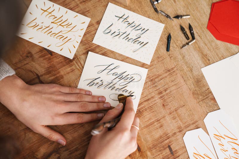 Calligrapher-skrivning när arbete utförs vid bord inomhus royaltyfri fotografi