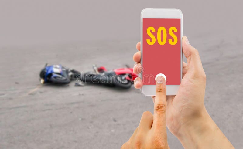 Hand holding a cellphone with emergency number SOS on the screen with a motorcycle accident in background. Hand holding a cellphone with emergency number SOS on the screen with a motorcycle accident in background