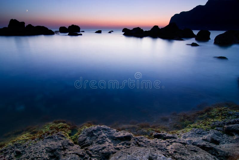 Calm blue water bay beyond the sunset