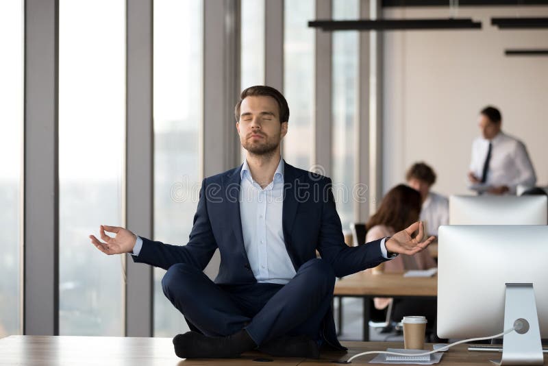 Calm Businessman Meditating On Office Desk Stress Relief Concept 库存照片