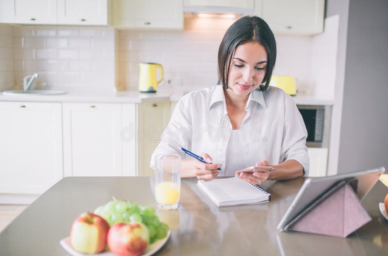 She is sitting at the table. Грустная девушка ставит тарелку на стол. Women sitting at the Table putting on Makeup. Girl with thick Bob Cut at the Table. The girl is sitting at the Table and writing Full-length.