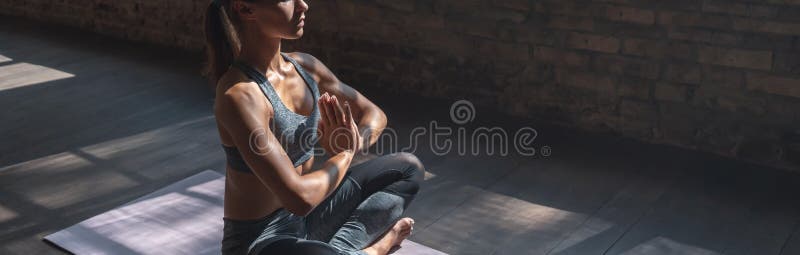 Sporty calm woman sit in lotus pose do yoga meditate in sunny gym, banner