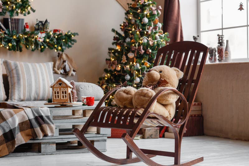 Calm image of interior modern home living room decorated christmas tree and gifts, sofa, table covered with blanket.