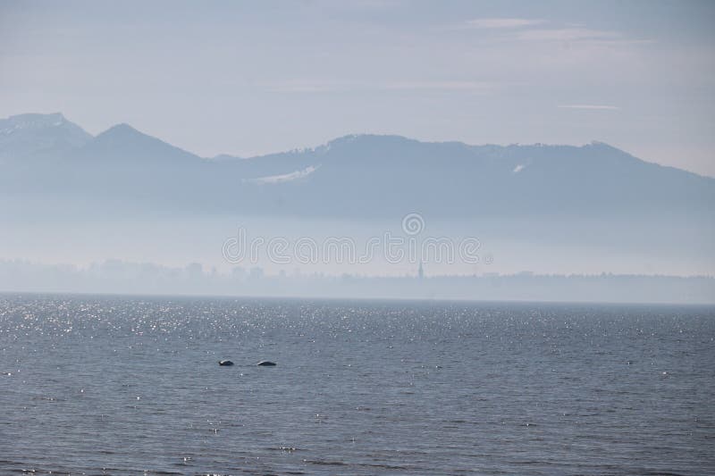 A calm ocean with a mountain range in the background royalty free stock photo