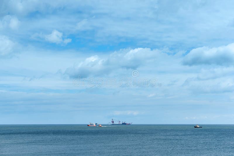 Calm sea without waves and blue sky, oil and gas drilling rig in the distance to the sea royalty free stock photos Calm sea without waves and blue sky, oil and gas drilling rig in the distance to the sea royalty free stock photos