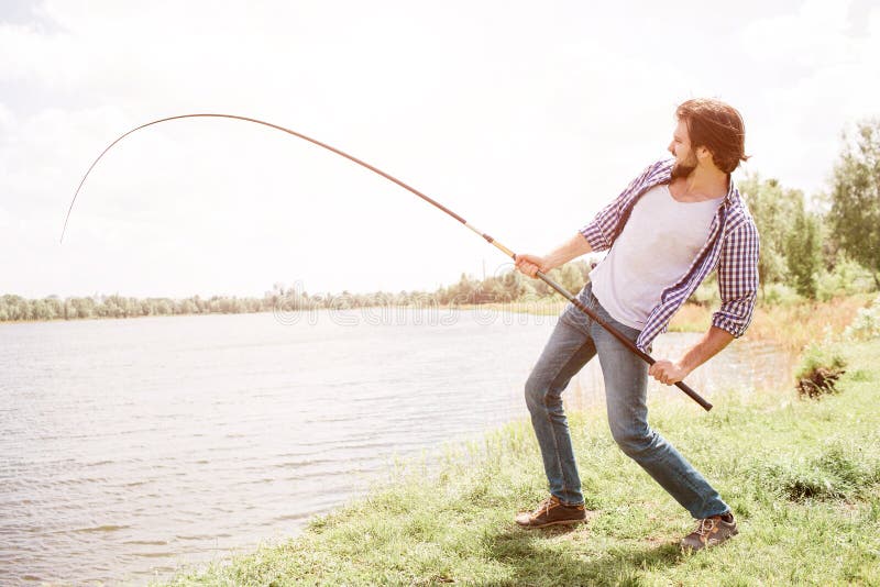 Calm and Thoughtful Guy is Standing at the Edge of Lake and