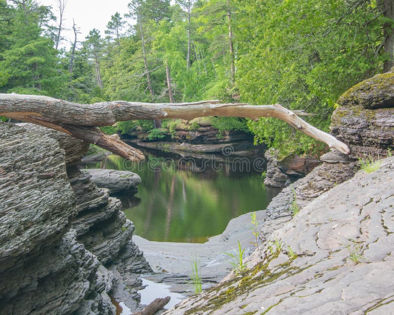 Calm waters on rocky forest shoreline of river in the Porcupine Mountains Wilderness State Park in the Upper Peninsula of Michigan