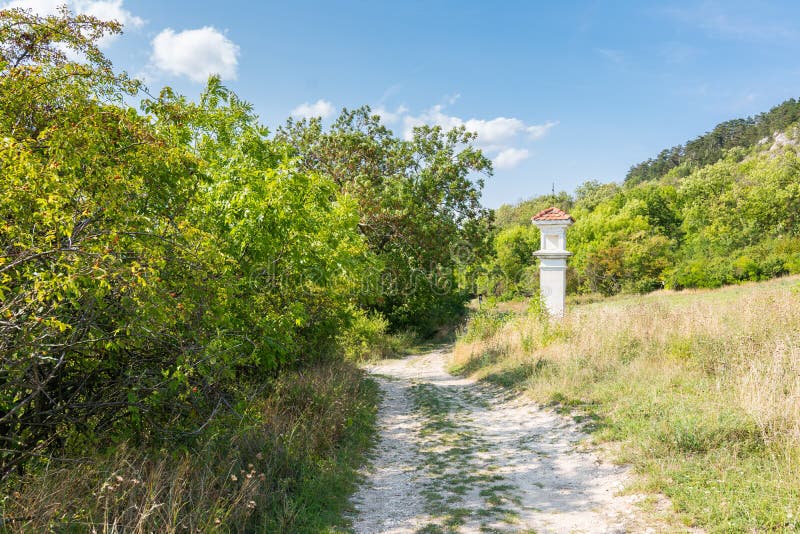 Calvario vicino al percorso con gli alberi ed i cespugli Cielo blu di estate fotografie stock libere da diritti Calvario vicino al percorso con gli alberi ed i cespugli Cielo blu di estate fotografie stock libere da diritti