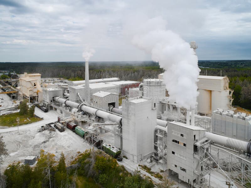 Calx roasting rotating furnace pipe and rail cars loading station at silica plant aerial view. Producing and transporting limestone products. Calx roasting rotating furnace pipe and rail cars loading station at silica plant aerial view. Producing and transporting limestone products