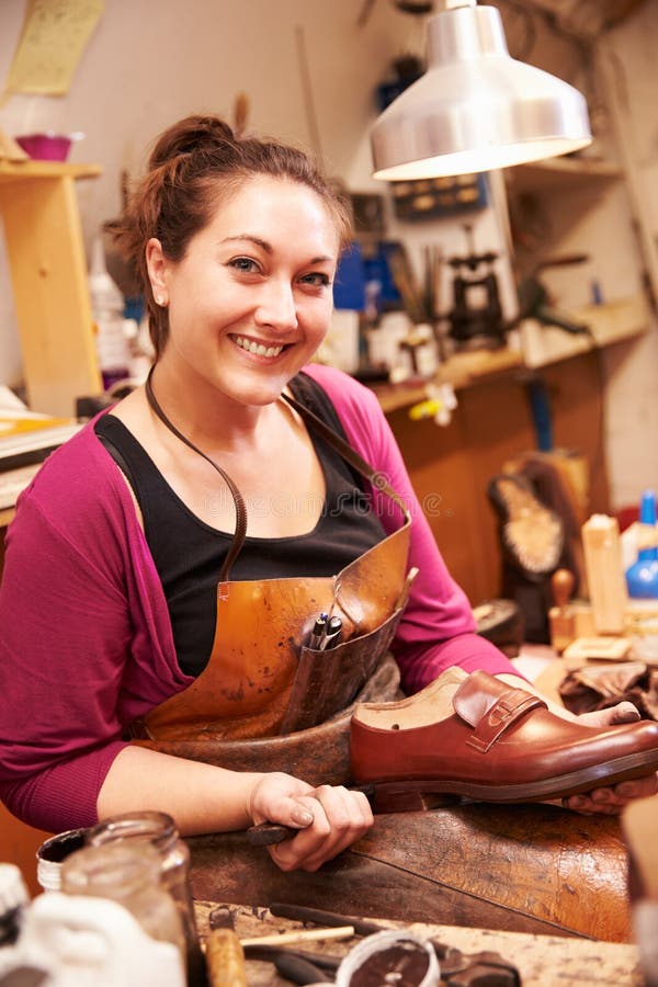 Calzolaio della donna che fa le scarpe in un'officina fotografia stock Calzolaio della donna che fa le scarpe in un'officina fotografia stock