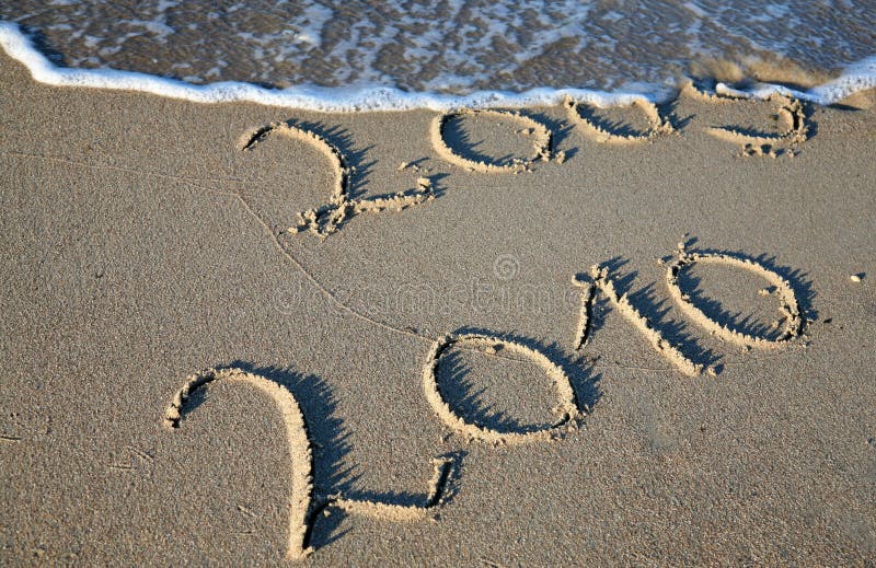 Symbol for the change of the year 2009 to 2010. Handwritten in the sand. The surf is about to wipe out the year 2009. Symbol for the change of the year 2009 to 2010. Handwritten in the sand. The surf is about to wipe out the year 2009.