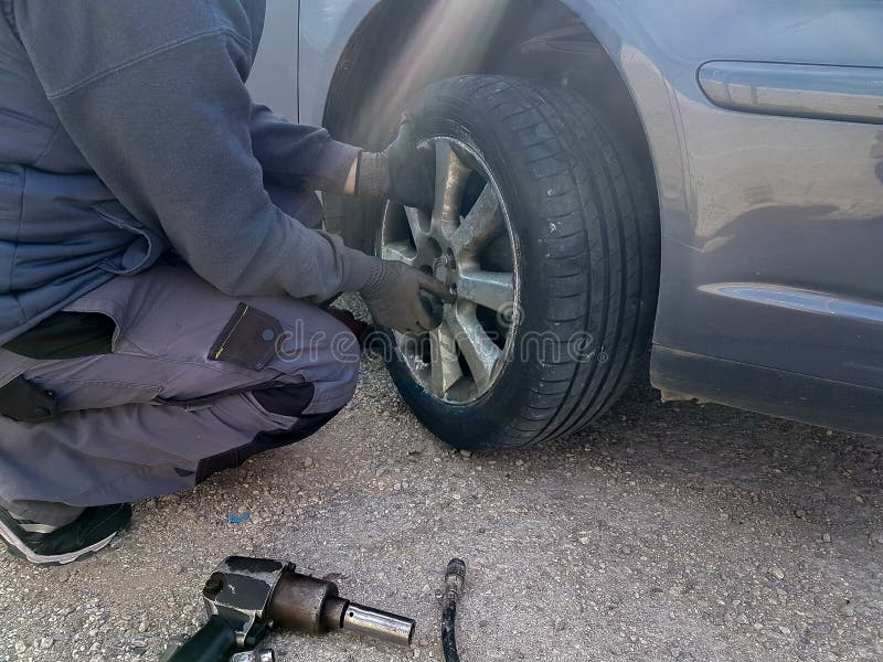 Cambio del neumático desinflado del coche substituir en la emergencia del problema del camino imagen de archivo Cambio del neumático desinflado del coche substituir en la emergencia del problema del camino imagen de archivo