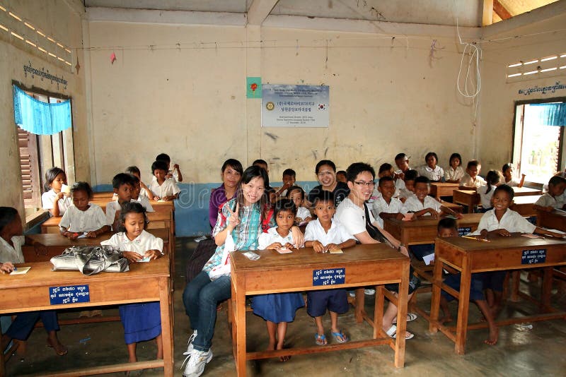 Volunteers visiting school at Kompong Phluk, Cambodia with teacher and students in the classroom. Volunteers visiting school at Kompong Phluk, Cambodia with teacher and students in the classroom.