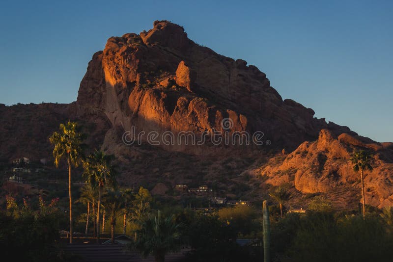 Popular Camelback Mountain with patches of sunlight cast upon the peak at sunrise, Paradise Valley, Arizona. Popular Camelback Mountain with patches of sunlight cast upon the peak at sunrise, Paradise Valley, Arizona