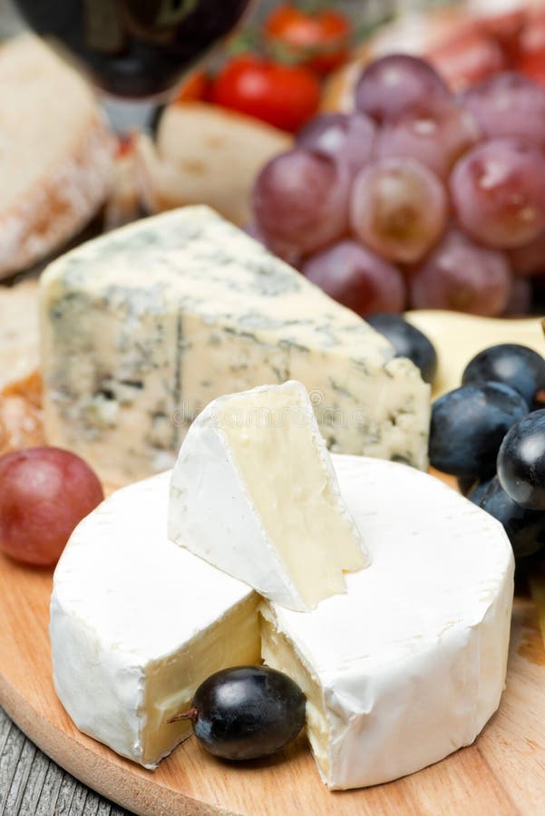 Camembert, Blue Cheese, Grapes and Walnuts on Wooden Board Stock Photo