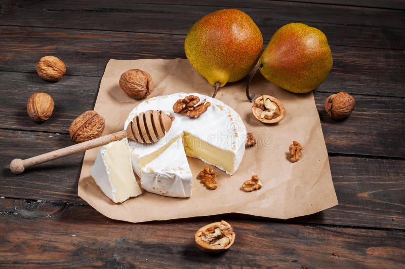 Camembert Cheese with Walnuts, Honey and Pears on Rustic Table Stock