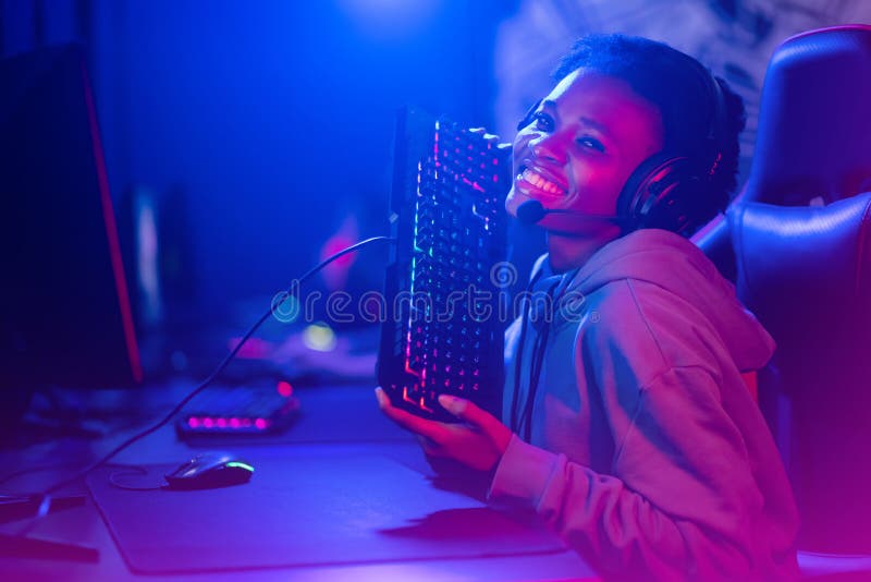 Camera d'studio di cyber-videogamer con tastiera personale per sedie a rotelle in neon immagine stock
