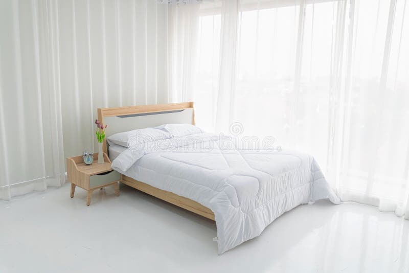 Camera da letto bianca con tende bianche e cuscini bianchi
