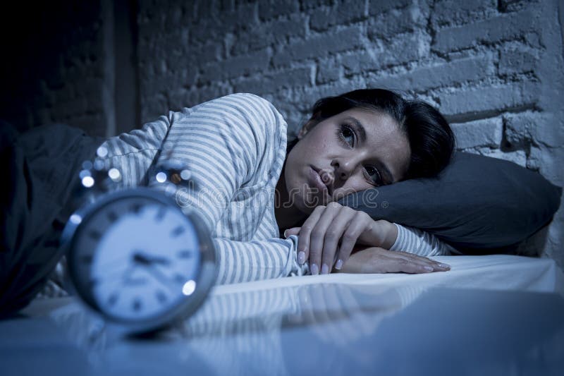 Camera da letto ispana della donna a casa che si trova a letto tardi alla notte che prova a dormire insonnia di sofferenza fotografia stock Camera da letto ispana della donna a casa che si trova a letto tardi alla notte che prova a dormire insonnia di sofferenza fotografia stock
