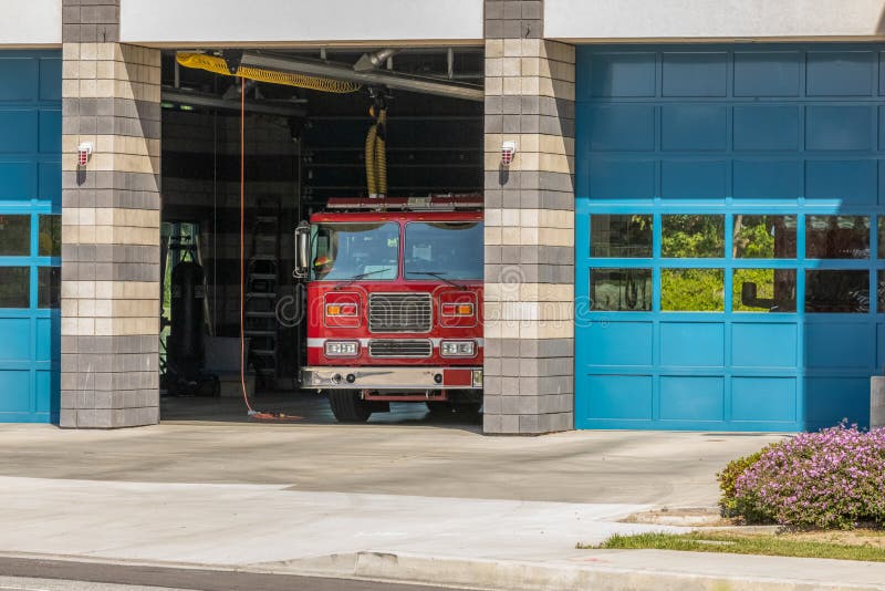 Camera di Firestation con il firetruck in baia aperta fotografia stock libera da diritti Camera di Firestation con il firetruck in baia aperta fotografia stock libera da diritti