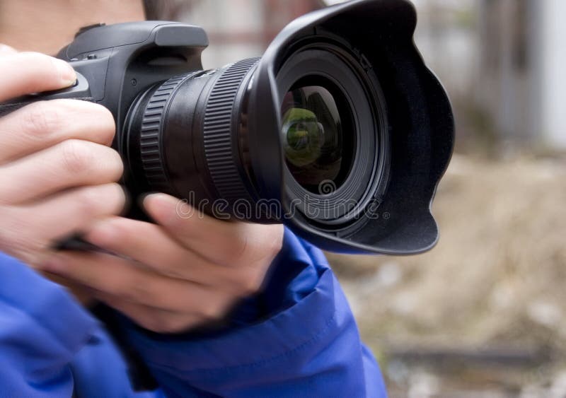 A photographer is holding a camera shooting photos. Body cam stock images, royalty-free photos and pictures