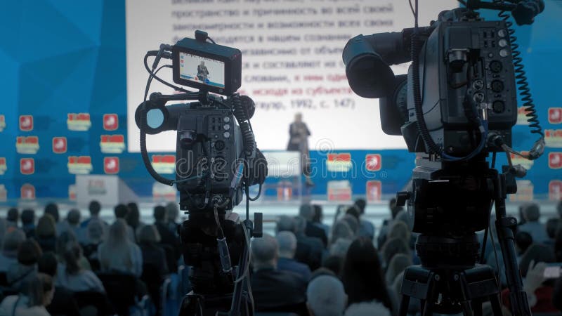 The cameraman makes video for television. Auditorium, seminar and lecture on business. Professional ideas, politics or