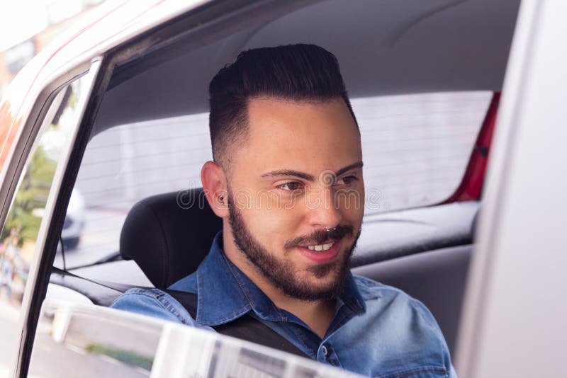 Camicia d'uso del denim dell'uomo d'affari che gode del viaggio nel sedile posteriore di fotografia stock libera da diritti Camicia d'uso del denim dell'uomo d'affari che gode del viaggio nel sedile posteriore di fotografia stock libera da diritti