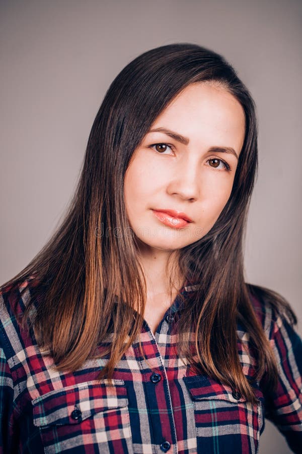 Camicia di plaid d'uso della giovane donna allegra felice che esamina macchina fotografica con il sorriso allegro e affascinante fotografia stock Camicia di plaid d'uso della giovane donna allegra felice che esamina macchina fotografica con il sorriso allegro e affascinante fotografia stock