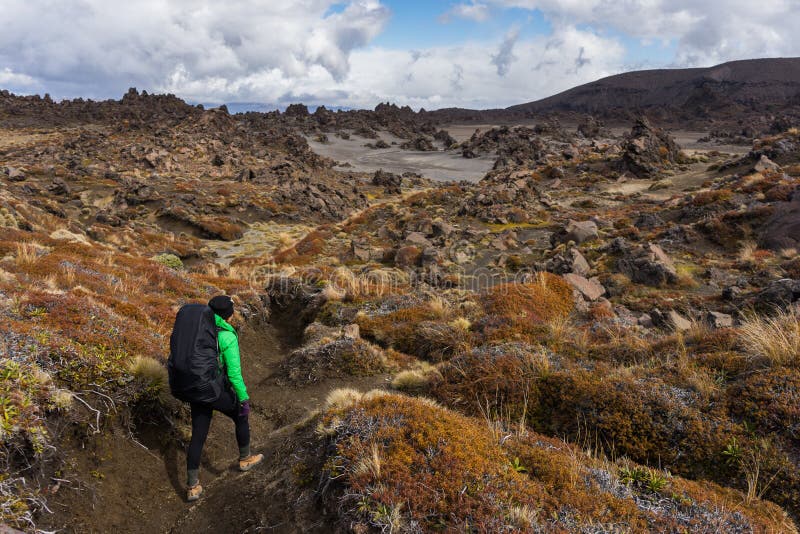 Caminante de la mujer que camina en área del postre por completo del forma de las rocas volcánicas foto de archivo libre de regalías Caminante de la mujer que camina en área del postre por completo del forma de las rocas volcánicas foto de archivo libre de regalías