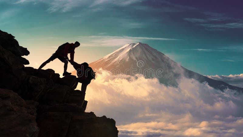 Caminantes asiáticos jovenes de los pares que suben para arriba en el pico de la montaña cerca de la montaña Fuji Concepto del tr