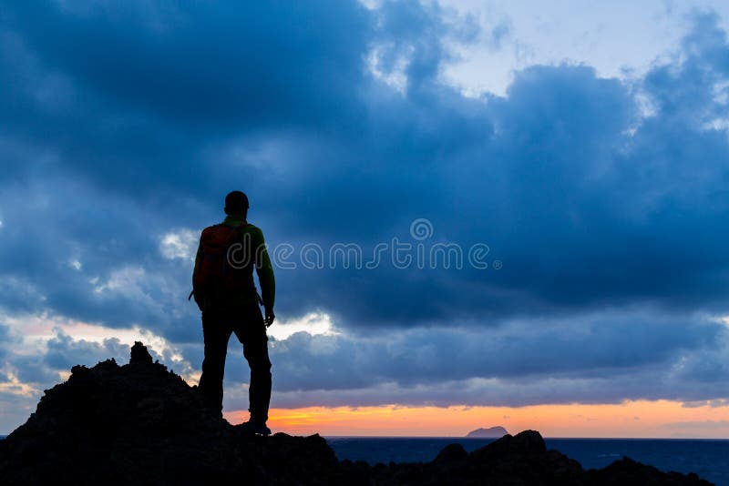 Caminar a backpacker de la silueta, paisaje inspirado de la puesta del sol