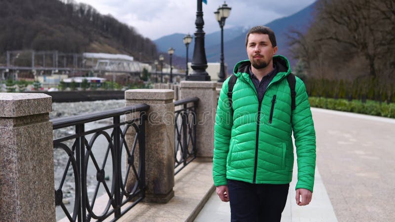 Caminar en la ciudad en la primavera o el día de otoño hombre está paseando solo en el terraplén de la ciudad