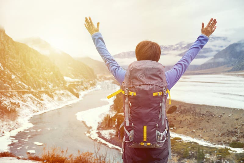 Caminar a la mujer con una mochila en la puesta del sol aumentó sus manos La chica joven hermosa está viajando en las montañas fotografía de archivo Caminar a la mujer con una mochila en la puesta del sol aumentó sus manos La chica joven hermosa está viajando en las montañas fotografía de archivo